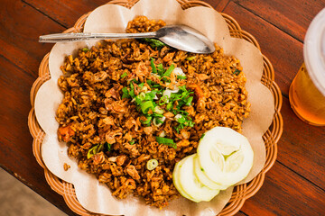 Freshly cooked fried rice on a woven bamboo plate with oil paper lining