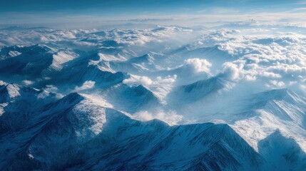 Fototapeta premium Ultra quality image of aerial view of snow-capped mountain peaks with blue sky and clouds.