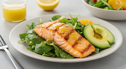 Grilled salmon fillet with avocado and salad on a plate, healthy meal close up