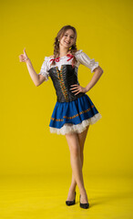 Woman Posing in Traditional Bavarian Outfit on Yellow Background