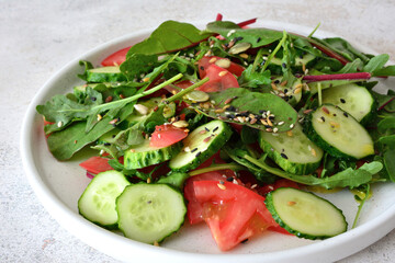 Fresh and Healthy Salad with Cucumber, Tomato, Greens and seeds close up