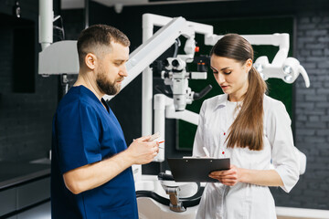  The concept of dental services and treatment.In a modern dental clinic, a doctor and a nurse...