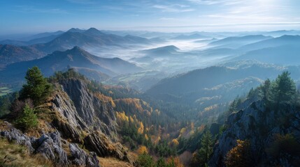 Ultra quality image of panoramic view from autumn mountain peak at sunrise in blue sky with misty valley below.