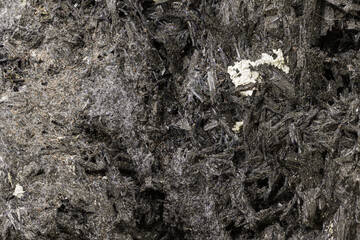 Macro photo of a dark mineral specimen showing fibrous structure and metallic sheen. Useful for geology, earth science, mineralogy, or educational purposes in stock photography