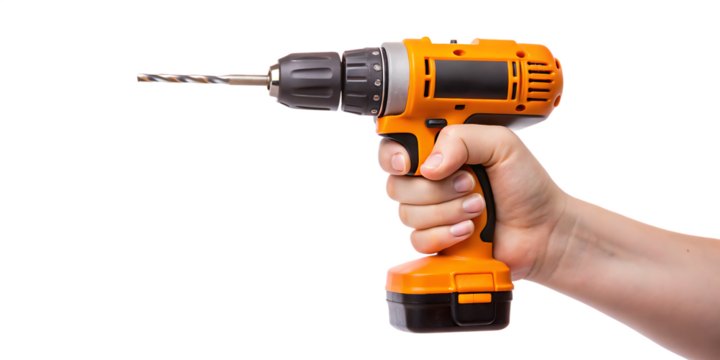 Hand holding an orange cordless drill isolated on a black background closeup view.