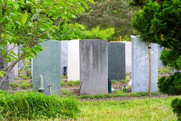 Rear view of tombstones at graveyard at Swiss City of Zürich on a spring day. Photo taken May 16th, 2025, Zurich Schwamendingen, Switzerland.