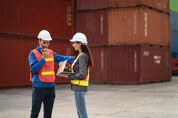 Caucasian man and woman engineer worker working with talking on Reach Stacker at container site	