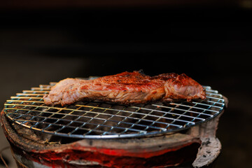 A perfectly grilled beef steak rests on a hot barbecue grill, ready to be served at a lively outdoor party or festive gathering.