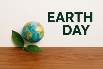 Miniature Earth with fresh green leaves on a wooden surface, symbolizing global environmental care and the importance of Earth Day initiatives 