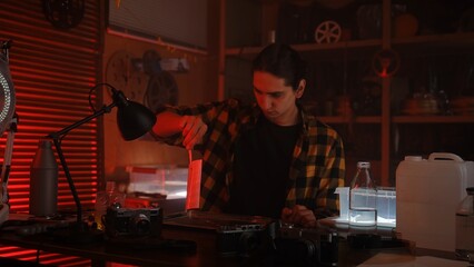Young Photographer Developing Photos in Darkroom