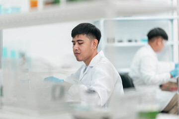 Medical science research team in modern laboratory conducting experiments, analyzing samples under...