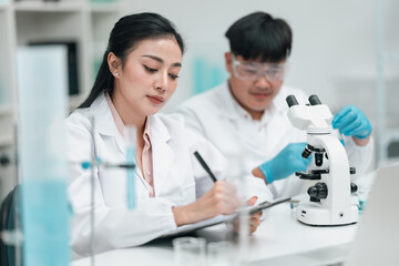 Medical research team conducting scientific experiments in a pharmaceutical laboratory, analyzing...