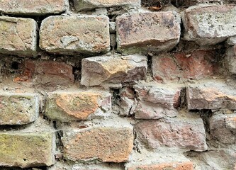 Exterior brick wall in urban street, construction and architecture. Brick wall. Brick wall with bricks of different sizes and shapes of gray color with addition of sand color. ancient serf brick wall 