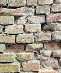 Exterior brick wall in urban street, construction and architecture. Brick wall. Brick wall with bricks of different sizes and shapes of gray color with addition of sand color. ancient serf brick wall 