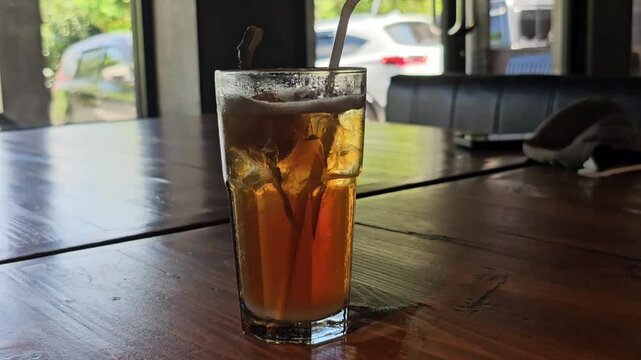 Iced tea or Es teh,flavored from tea leaves,served in glass with ice,it has been chilled and cooled,sweetened with sugar,syrup,mixed with fruit-flavored syrup or unsweetened