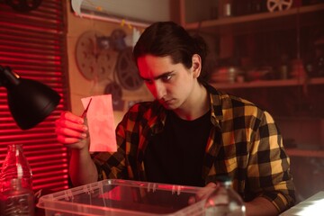 Young Photographer Developing Film In Darkroom Setting