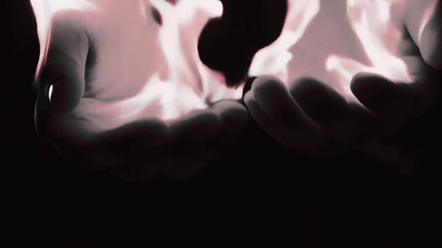 Close-up of hands holding fire with dramatic lighting, slow-motion effect [with copy space]