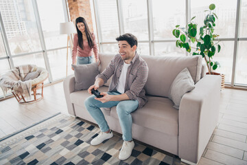 Obraz premium Young couple enjoying leisure time together in a cozy living room setting during a sunny day indoors, with natural daylight.