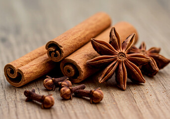 Cinnamon Sticks with Star Anise and Cloves on Dark Wood – Aromatic spices arranged in a rustic setting, ideal for culinary, seasonal, or wellness-themed visuals.

