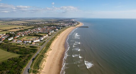 Fototapeta premium Coastal Town View from Above with Sandy Beach and Ocean Waves