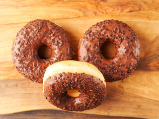 Sweet tasty chocolate donuts on wooden board. Popular desert and snack. Fine bakery product.