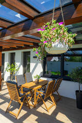 This image showcases a modern residential home with stylish outdoor seating, highlighting the elegant design and inviting atmosphere of the patio space on a sunny day
