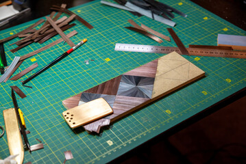 Geometric marquetry panel on cutting mat with veneer strips