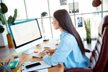 Professional woman working in a well-lit modern office environment, demonstrating dedication and...