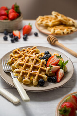 Belgian homemade waffles with strawberries, blueberries and honey 