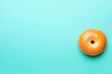 Plain glazed bagel on teal background