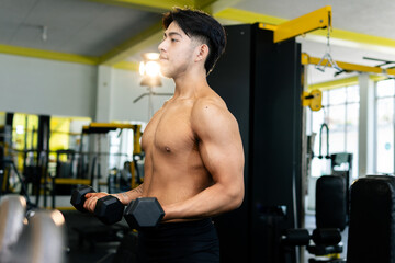 Bodybuilder lifting weights, concentrating on fitness goals in gym