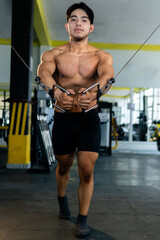 Bodybuilder performing cable fly exercise in gym