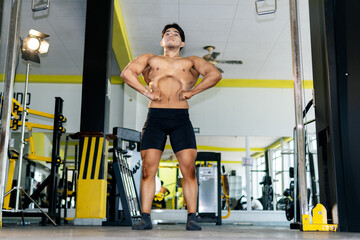 Young bodybuilder showing his muscles in a gym