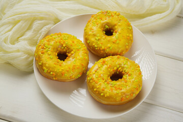 Yellow donuts on a white table. Sweet donuts