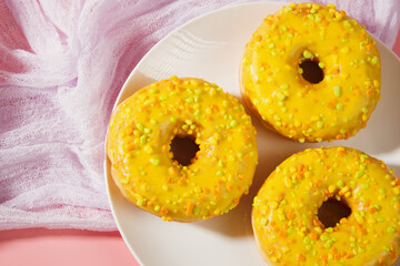 Yellow donuts on a pink background. Sweet donuts