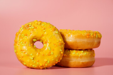 Yellow donuts on a pink background. Sweet donuts
