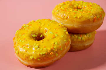 Yellow donuts on a pink background. Sweet donuts