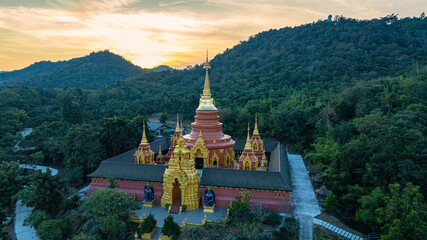 aerial view of the golden gate with intricate golden architecture at Phra Yai Wat Phra That Doi Phra Chan (Daibutsu) temple..A stunning view of a traditional temple surrounded by lush greenery