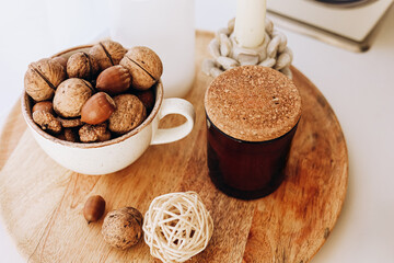 Decorative bowl of nuts and jar with cork lid on wooden surface in cozy setting