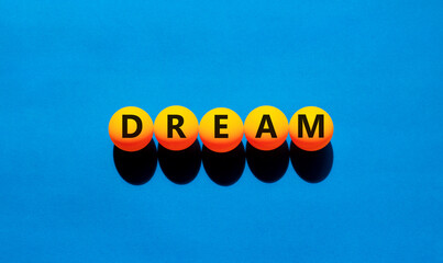 Dream symbol. Concept word Dream on beautiful yellow tennis ping pong balls. Beautiful wooden table...