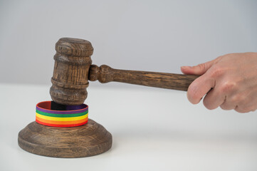 Judge hits gavel on rainbow bracelet. 
