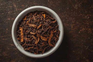 Black Tea and Herbal Loose Leaf Tea with Dried Herbs and Spices in Rustic Bowl - Aromatic Beverage for Relaxation and Wellness