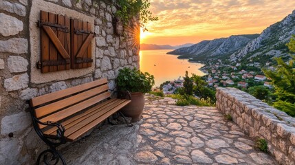 A serene sunset over a coastal village viewed from a stone pathway, featuring a wooden bench and lush greenery, Ideal for travel blogs, promotional materials, or as a backdrop for relaxation themes,