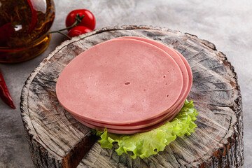 Sliced boiled sausage over board