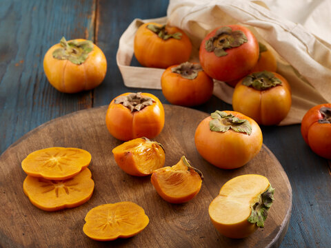 Persimmons, Fuyu, on cutting board