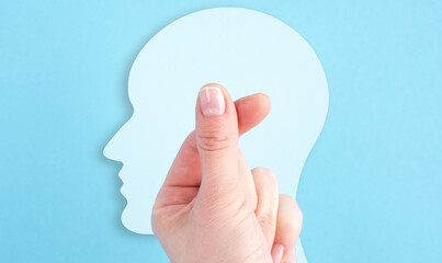 A hand is holding a paper head with a thumb up