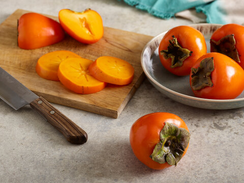 Fresh persimmons on cutting board