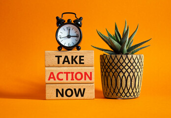 Take action now symbol. Wooden blocks with words Take action now. Beautiful orange background with...