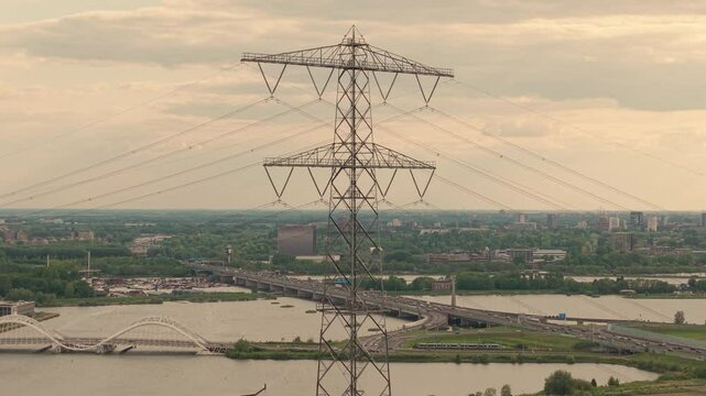 Aerial view of Electrical Grid Infrastructure in Amsterdam, The Netherlands, Power Transmission Mast in front of A10 highway during rush hour
