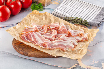 Sliced pork bacon over board
